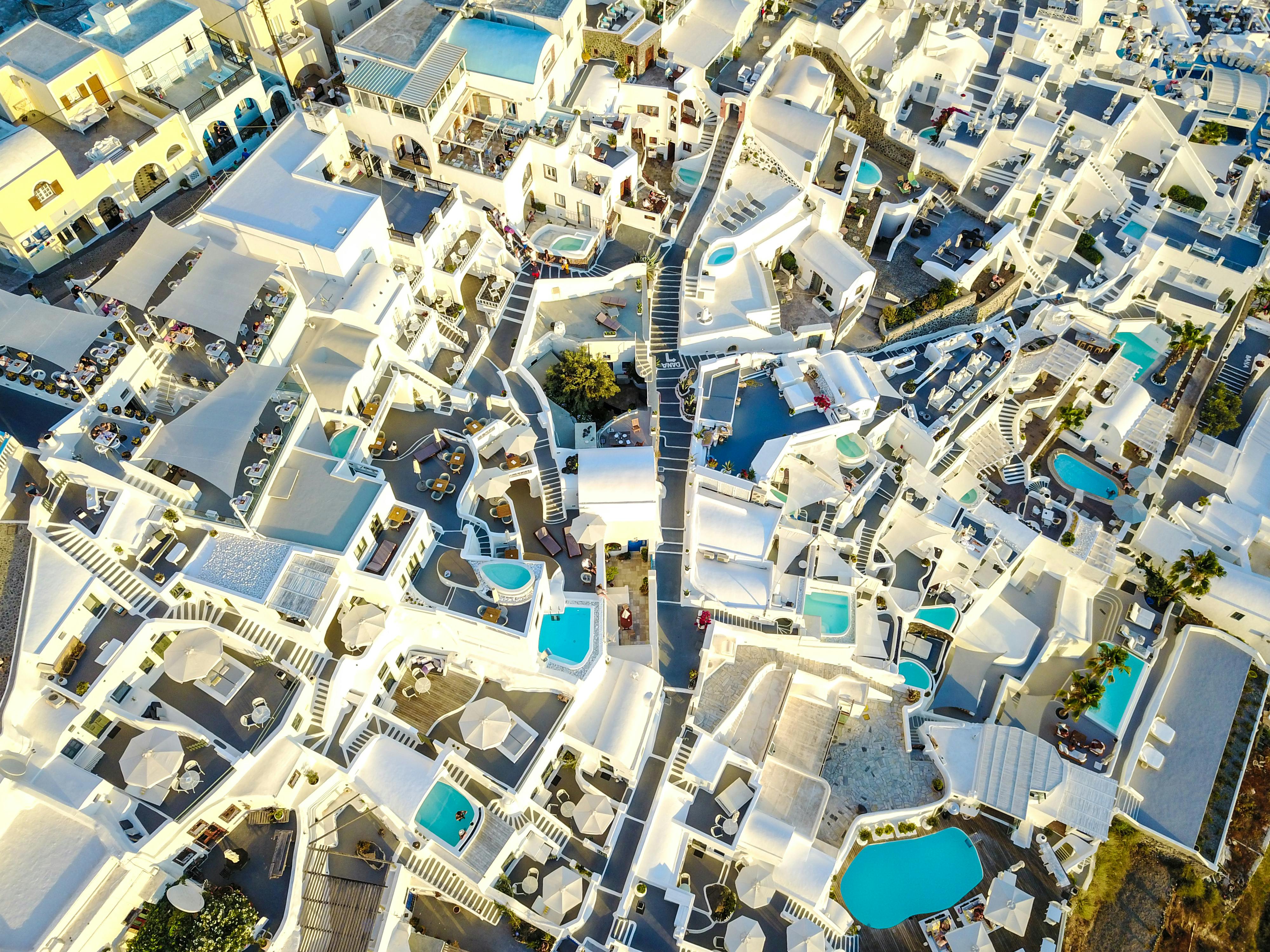 Breathtaking aerial view of Santorini luxury hotels with infinity pools overlooking the caldera